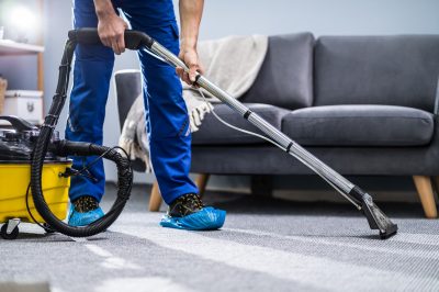 person-cleaning-carpet-with-vacuum-cleaner-picture-id1191080465.jpg