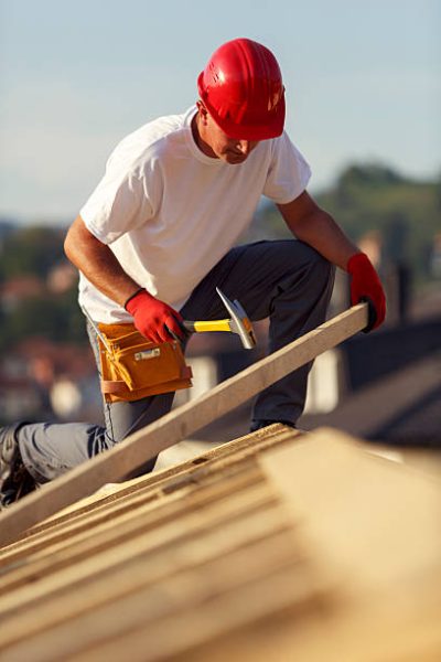 construction-roofer-nailing-wood-board-with-hammer-picture-id514798543.jpeg
